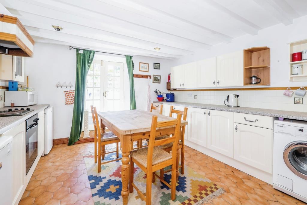 Lot: 72 - DETACHED BARN CONVERSION IN A LOVELY COUNTRYSIDE SETTING - Kitchen with fitted unit and kitchen table - photograph provided by seller